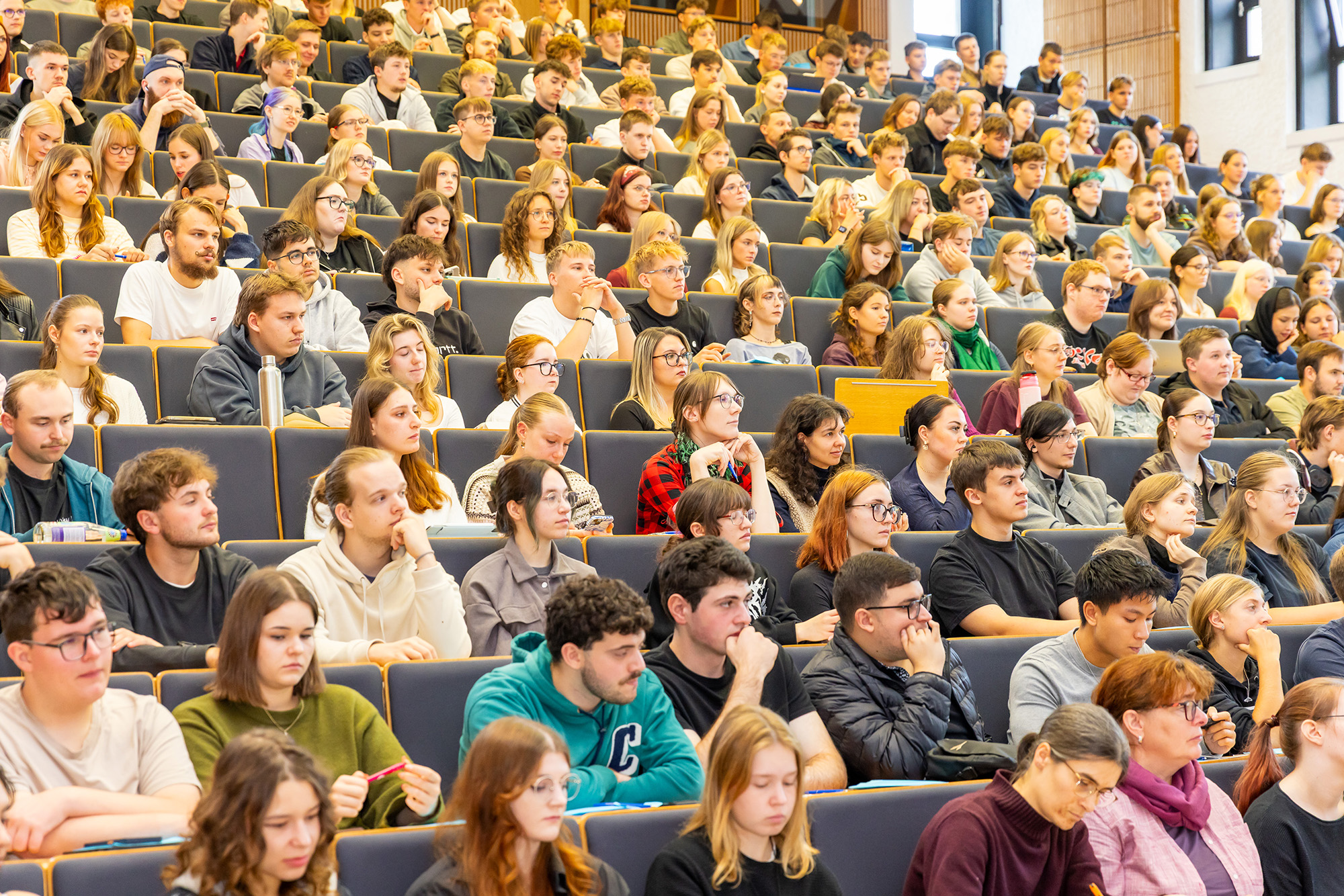 Ein vollbesetzter Hörsaal, von vorn fotografiert
