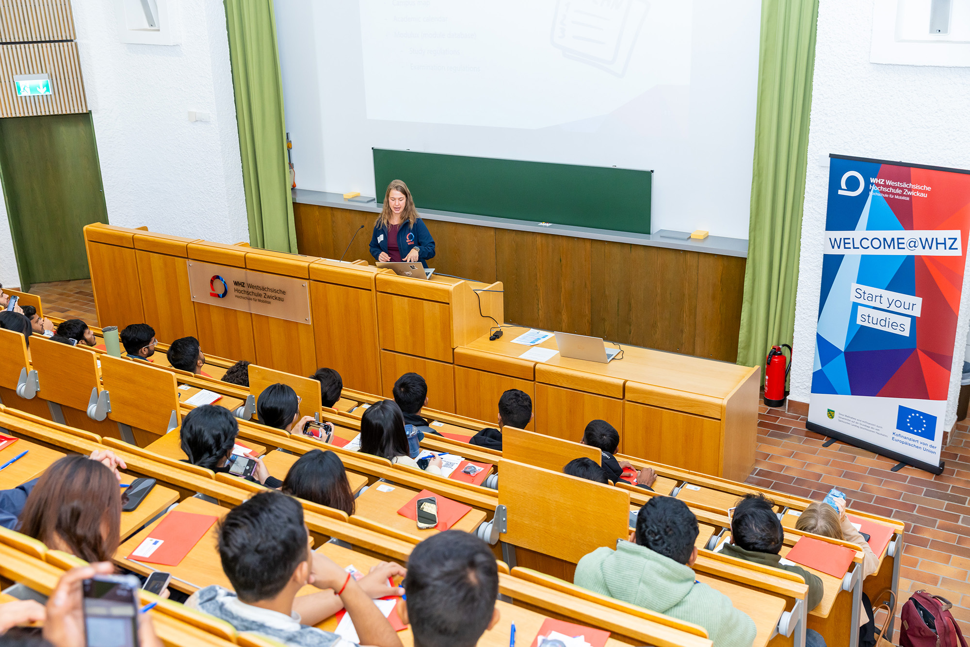 Ein Hörsaal mit Studierenden, von hinten fotografiert. 