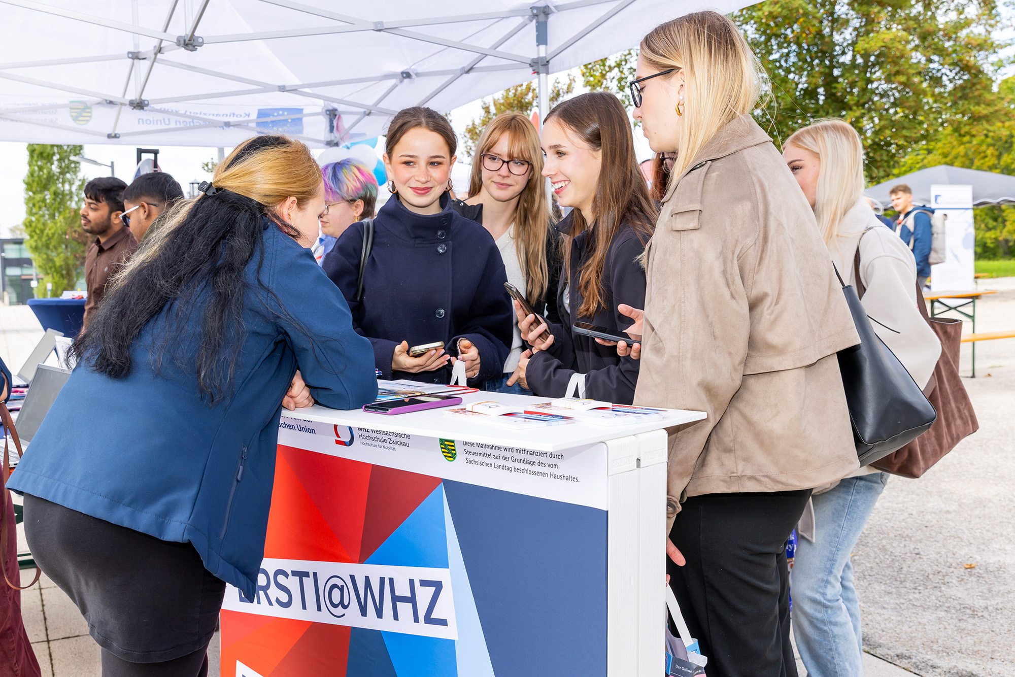 Studierende an einem Infostand der Hochschule. 