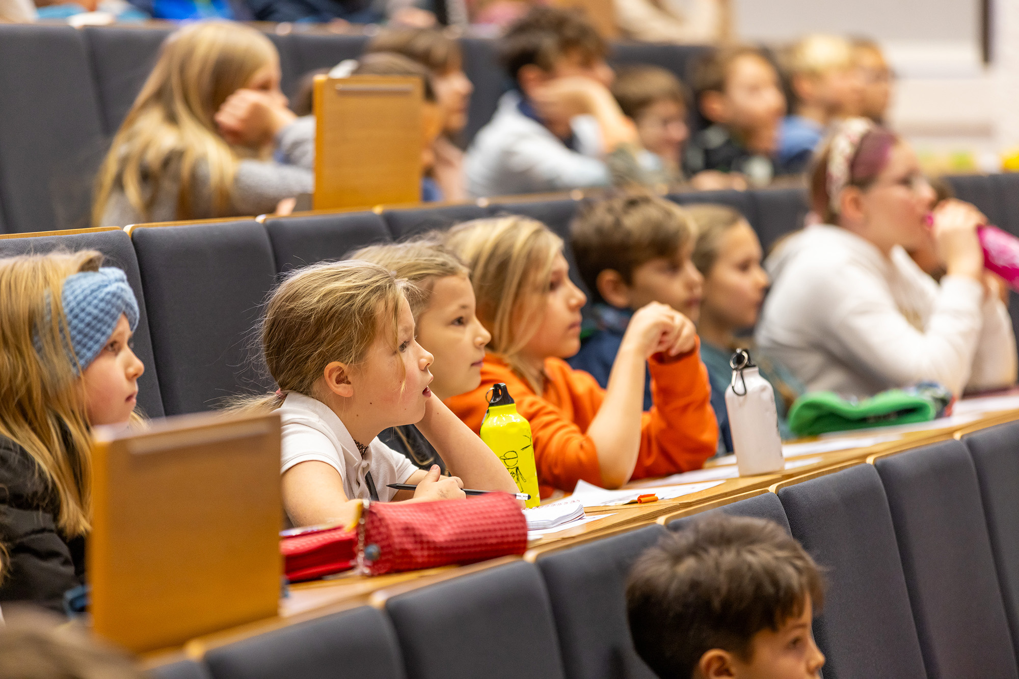 Kinder verfolgen aufmerksam eine Vorlesung der Kinderuni