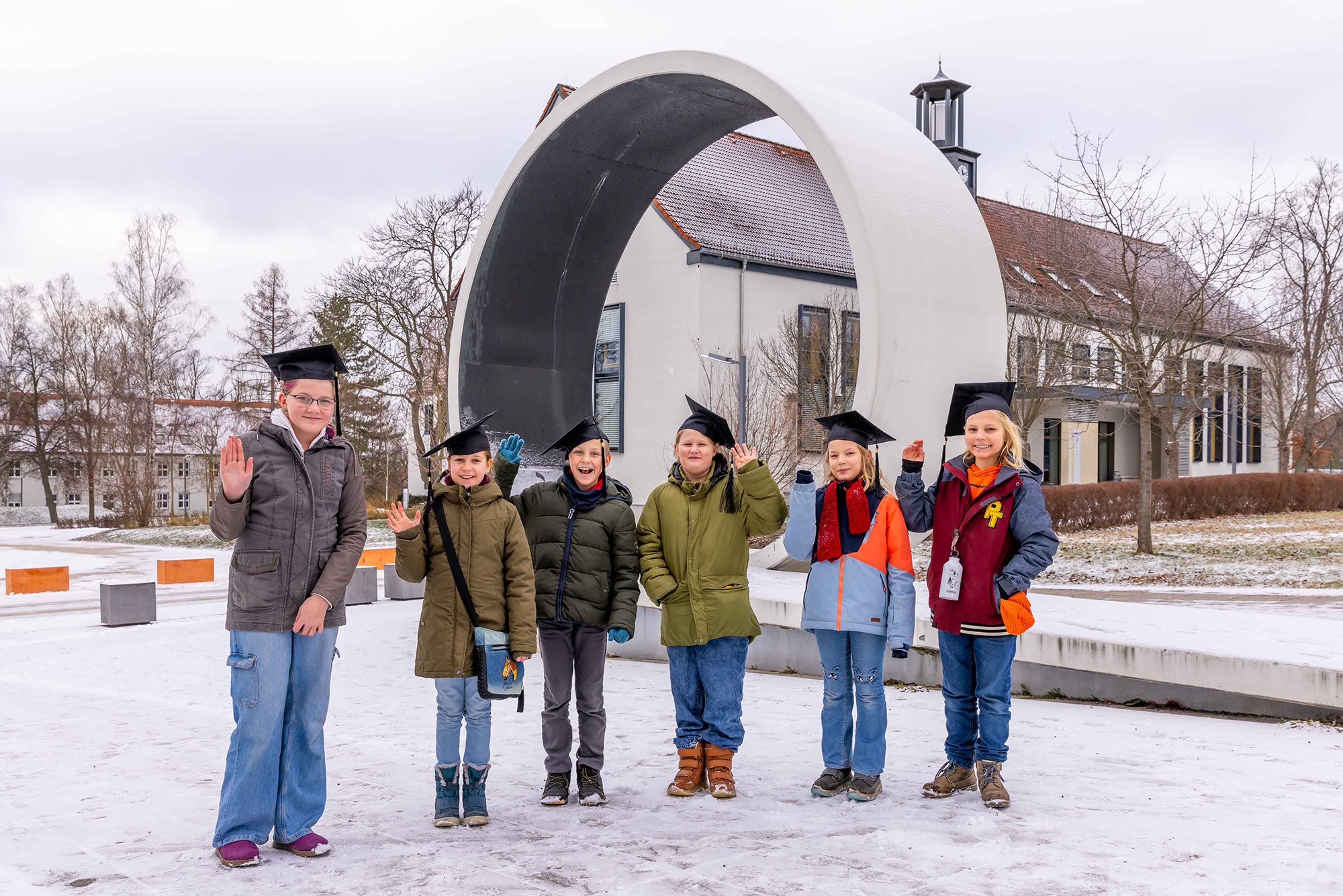 Kinder stehen mit Doktorhüten vor dem WHZ-Looping