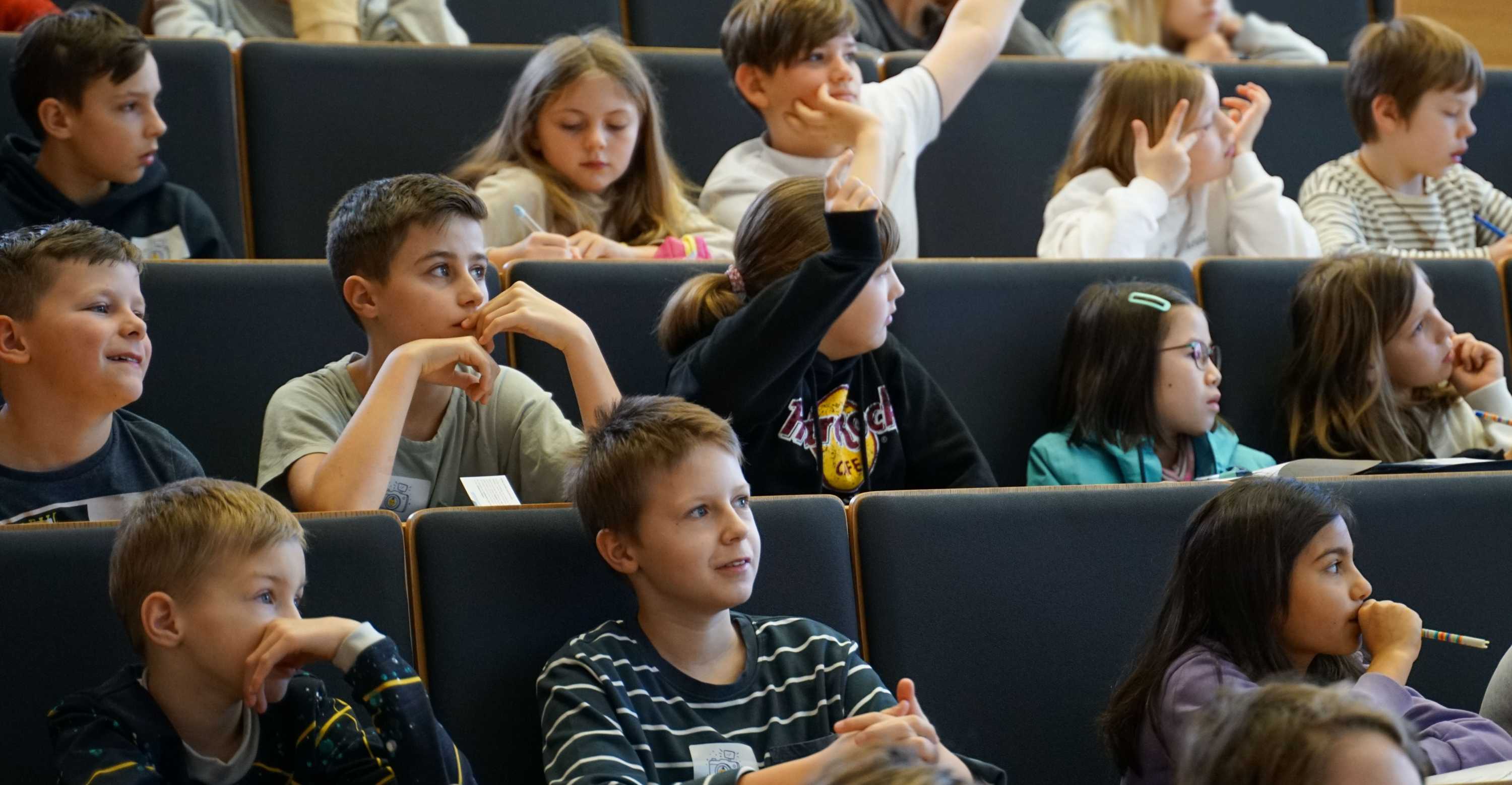 KinderUni 2026, Vorlesung zu KI, Kinder sitzen im Hörsaal, einige melden sich