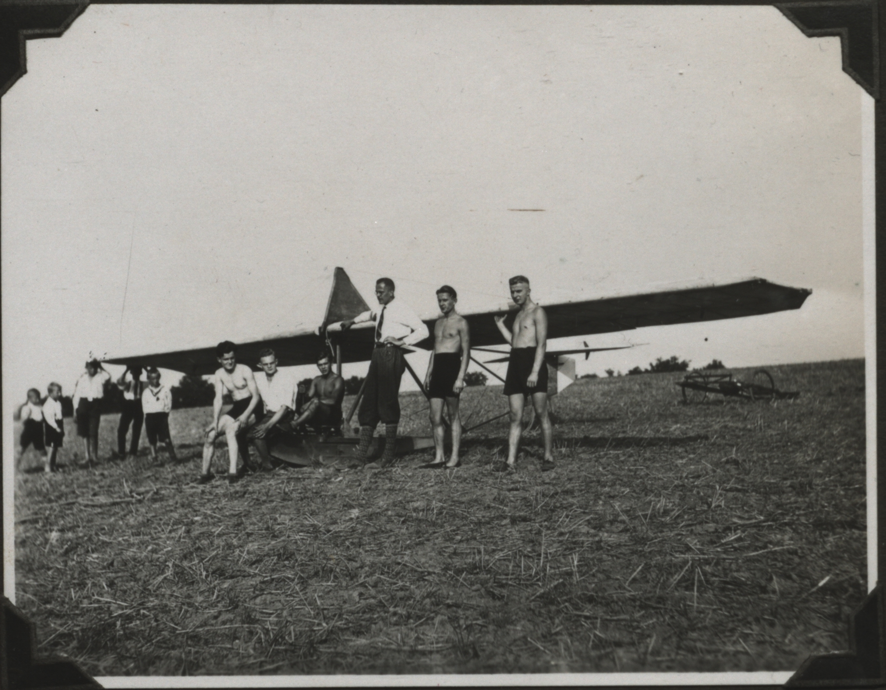 Studierende in kurzen Hosen stehen vor einem alten Flugzeug
